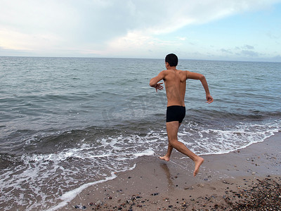 精力充沛的人跑进海里游泳