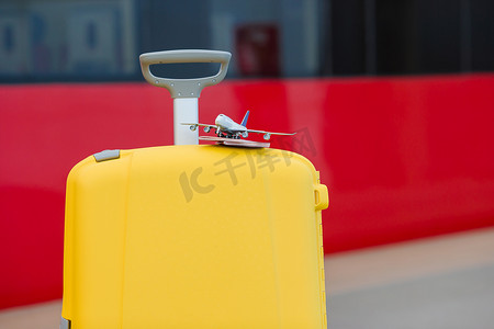 火车站黄色行李上的特写红色护照和飞机小模型