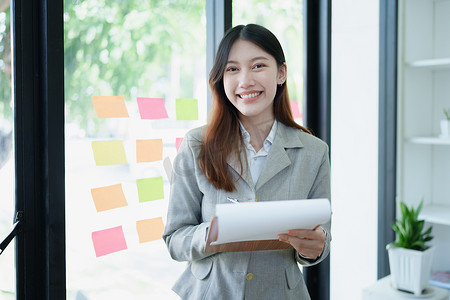 一位体贴的亚洲女商人在办公室查看财务报表并制定营销计划的肖像