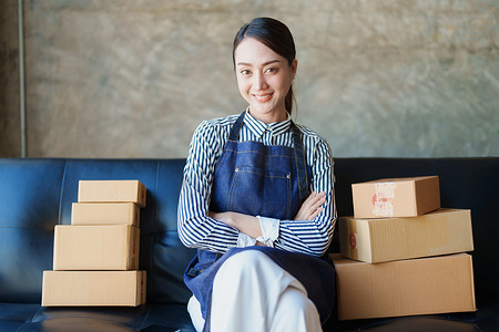 独立亚洲女性在线卖家包装产品的小型企业企业家发送给客户和中小企业交付概念