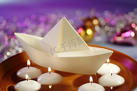 水碗中漂浮的蜡烛和纸船