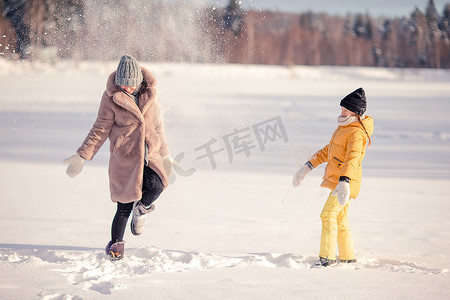 圣诞户外摄影照片_妈妈和孩子的家人在圣诞前夕在户外度假