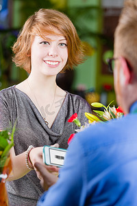 优惠券卡券摄影照片_使用电子优惠券的年轻花店顾客