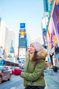 纽约市妇女作为时代广场游客或年轻快乐的女人来访美国纽约曼哈顿。