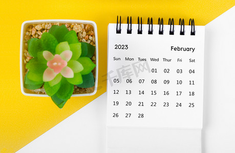 2023 年 2 月的 2023 年月度台历，黄色背景上有小树。