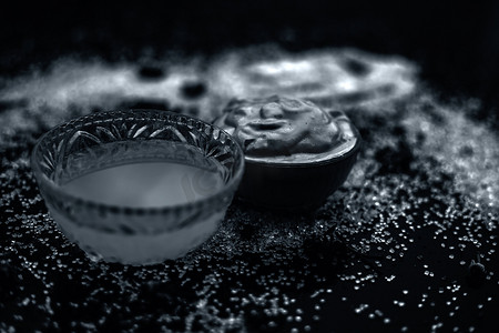Ubtan/面罩/木尔塔尼米蒂面膜或漂白土在玻璃碗中的木质表面，由木尔塔尼米蒂和椰子油组成，用于补救或治疗晒黑。在木质表面上。