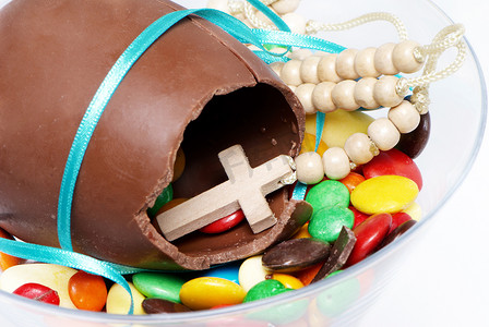 复活节巧克力蛋、糖果和玻璃杯中的十字架
