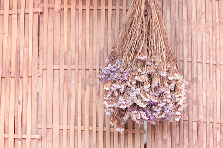竹背景上挂着的一束干花