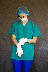 手术帽摄影照片_医生或护士表格、穿医用制服的女性肖像、面具、手套和手术帽