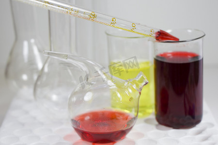 液体流体摄影照片_无菌台、玻璃器皿和吸管中的实验室化学液体元素和研究诊断、仪器和物品。