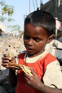 贫困儿童摄影照片_在贫困中吃食物