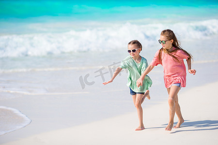 小孩在沙滩玩耍摄影照片_可爱的小孩在沙滩上一起玩耍