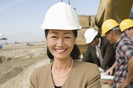 工人合影摄影照片_现场女测量员和建筑工人合影