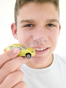 拿玩具汽车的男孩摄影照片_小男孩拿着玩具车微笑