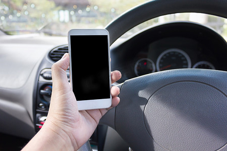 在驾驶座的车内手持空白屏幕智能手机，上网