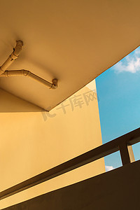 排水管摄影照片_黄色建筑墙上的下水道或排水管