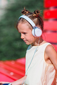 音乐节画册摄影照片_小可爱女孩在公园里听音乐