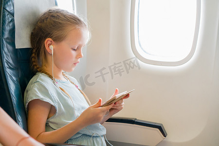 可爱的小女孩乘飞机旅行。
