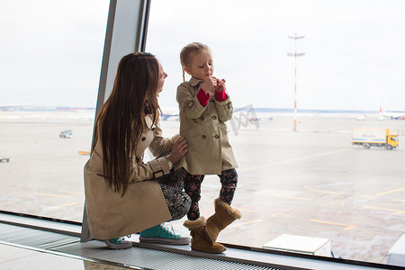 航空母摄影照片_母亲和小女儿在机场航站楼望着窗外