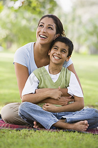 Mother and son outdoors in park bonding and smilingMother and son outdoors in park bonding and smiling 母亲和儿子在户外公园里亲昵和微笑