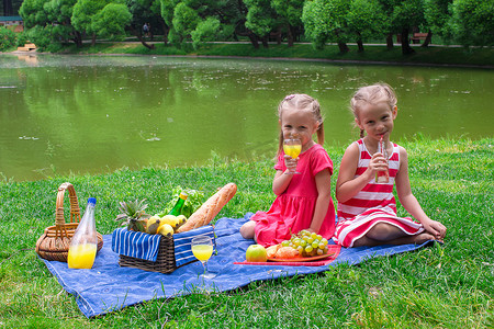 阳光明媚的日子里，可爱的小孩在公园野餐