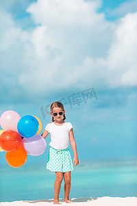 可爱的小女孩在沙滩上玩气球