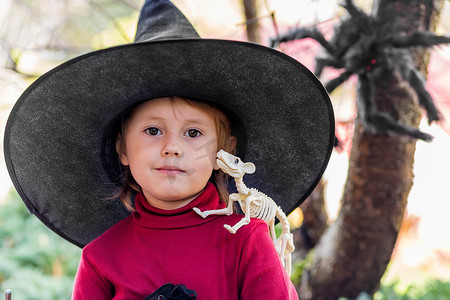 魔法师摄影照片_万圣节派对上穿着女巫服装的小女孩做出不同的面孔