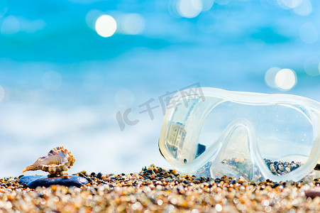 蓝色面罩摄影照片_浮潜面罩和沙滩贝壳
