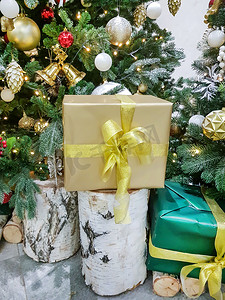 房间圣诞树附近的桦树桩上，用金纸包裹着漂亮的盒子，上面放着圣诞礼物