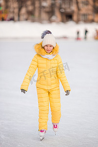 可爱的小女孩在冬季雪天在户外滑冰