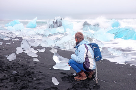 冰岛黑沙滩上冰岩上的游客