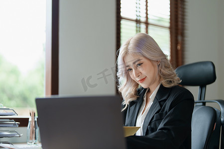财务、规划、营销和会计，亚洲员工在工作中使用文件和计算器检查财务报表的肖像