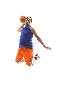 微笑的篮球运动员在空中跳跃，膝盖弯曲