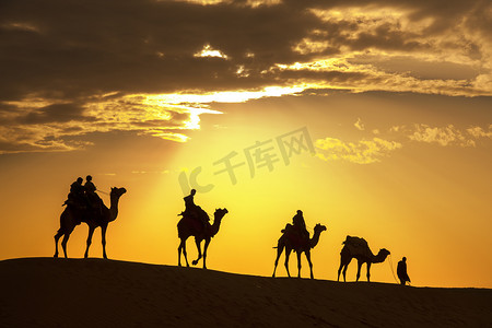 沙漠当地人骑着骆驼穿过塔尔沙漠