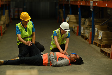 男主管躺在水泥地上不省人事，同事们帮助受伤的人进行急救