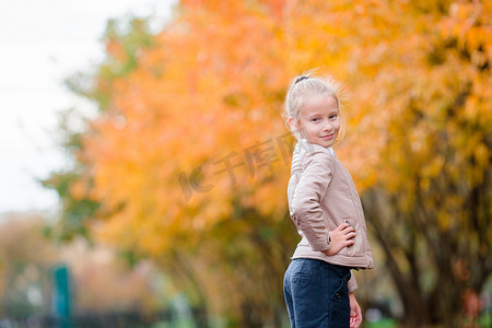 秋天黄树背景可爱小女孩的画像