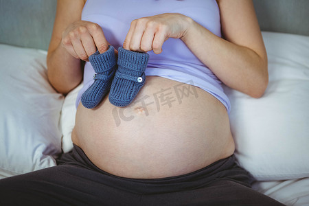 孕妇在颠簸处拿着婴儿鞋
