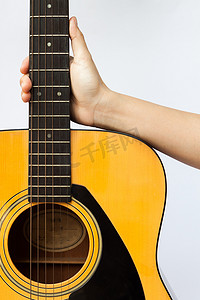 白色背景中拿着原声吉他的女人的手