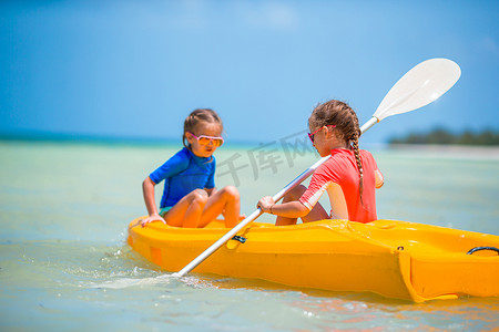 喜欢在黄色皮划艇上划皮划艇的可爱小女孩