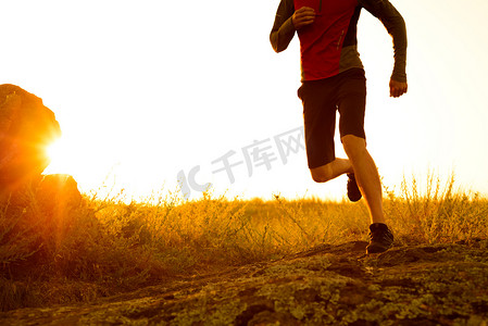日落时在落基山小径上奔跑的运动员腿部特写。
