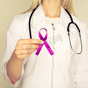 儿童疾病预防摄影照片_身穿白色制服的女医生手持紫色丝带，用于治疗 ADD、ADHD、阿尔茨海默病、Arnold Chiari 畸形、儿童偏瘫中风、癫痫、慢性急性疼痛、克罗恩病