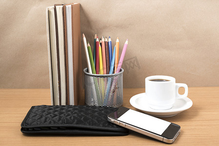 办公桌：咖啡和电话，一叠书，钱包，彩盒