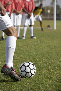 一名足球运动员在反对派的背景下任意球的低位