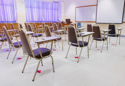 教室里空荡荡的旧演讲椅，保持社交距离