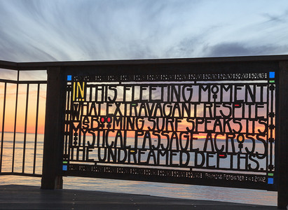 诗朗诵片尾摄影照片_日落时拉古纳海滩的彩色玻璃栅栏