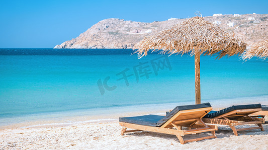 夏季的米科诺斯海滩，带雨伞和豪华沙滩椅床，希腊蓝海
