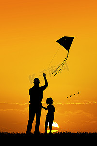 风筝玩具摄影照片_父亲和儿子在日落时放风筝