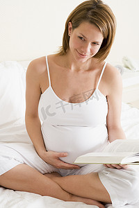 孕妇在卧室看书微笑