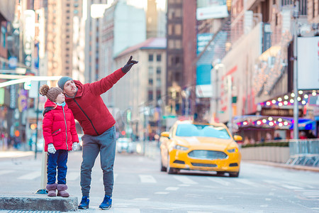 父亲和小孩在纽约市度假时在时代广场的一家人