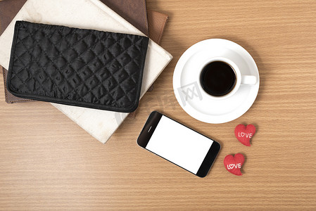 叠杯子摄影照片_办公桌：带电话的咖啡、一叠书、钱包